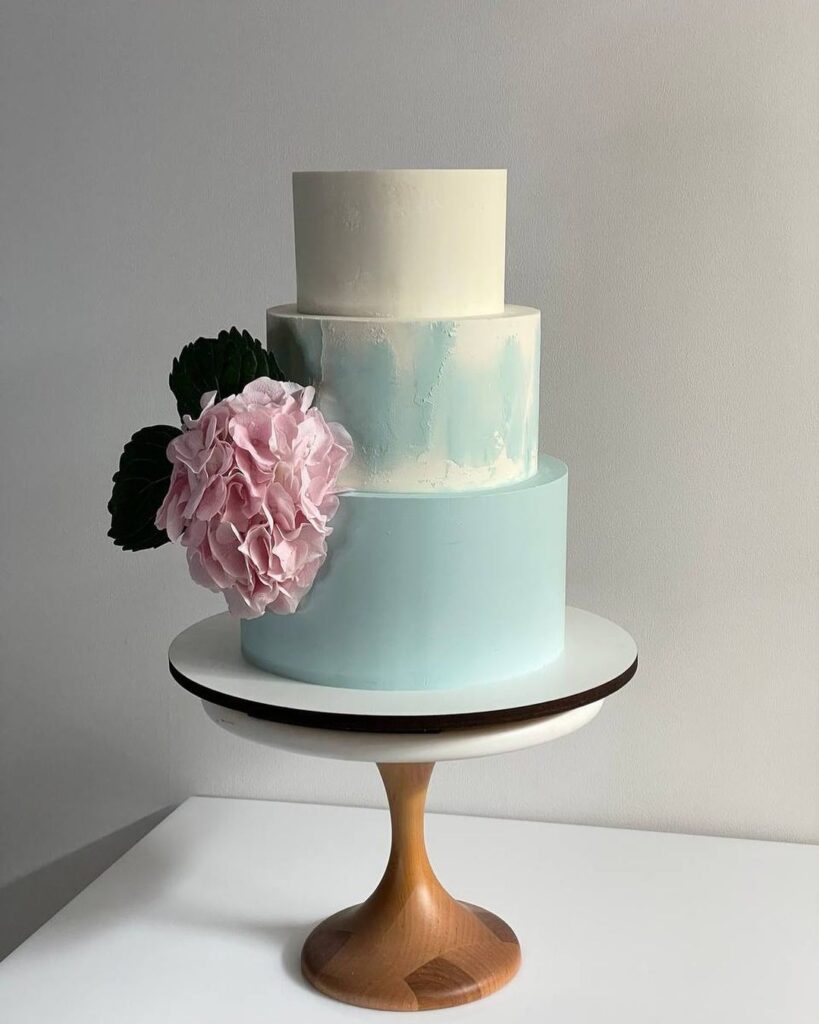 Триярусний весільний торт прикрашений великою квіткою Трехъярусный свадебный торт украшенный большим цветком