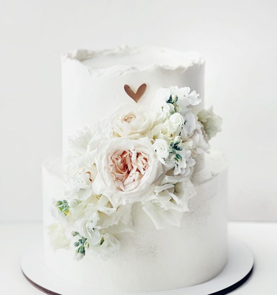 Кремовый двухъярусный торт украшенный цветами Кремовый двухъярусный торт украшенный цветами