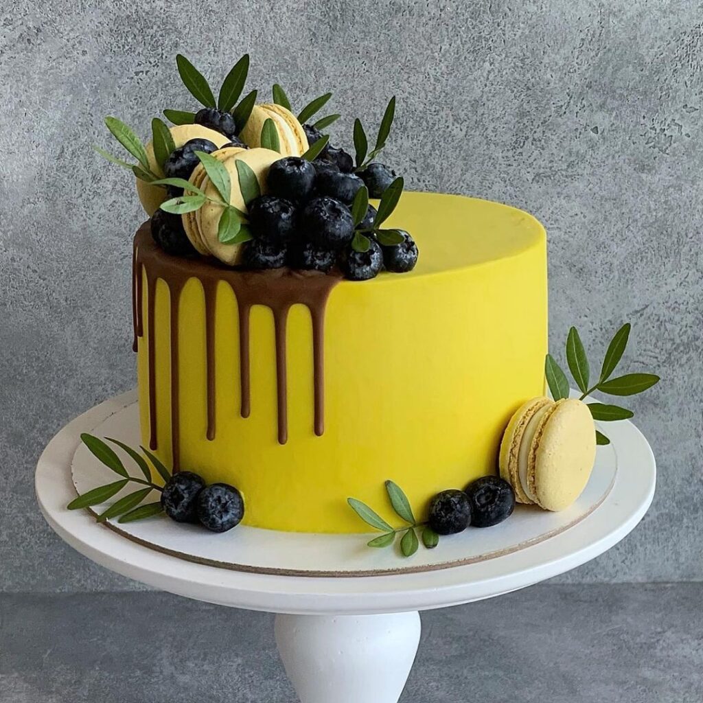 Жовтий торт прикрашений макарунами Желтый торт украшенный макарунами