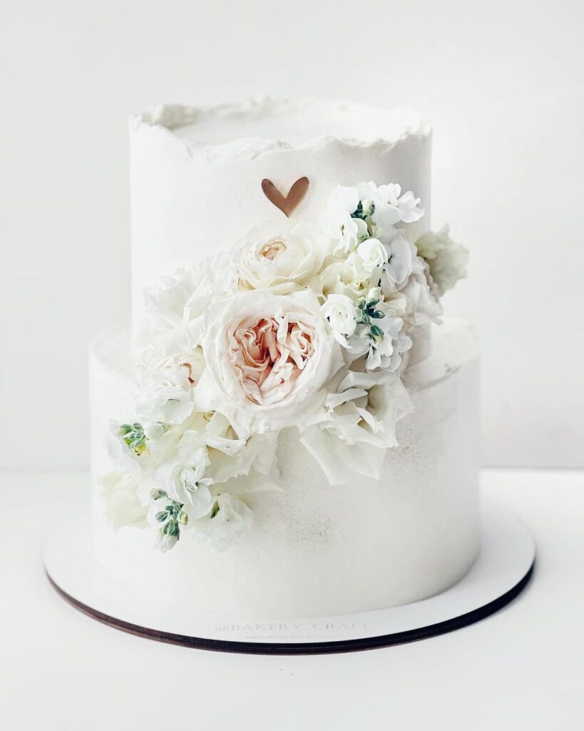 Білий торт прикрашений білими квітами Белый торт украшенный белыми цветами