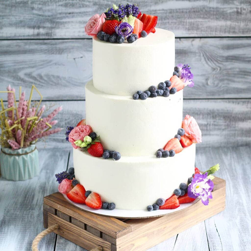 Весільний торт прикрашений ягодами та квітами Свадебный торт украшенный ягодами и цветами